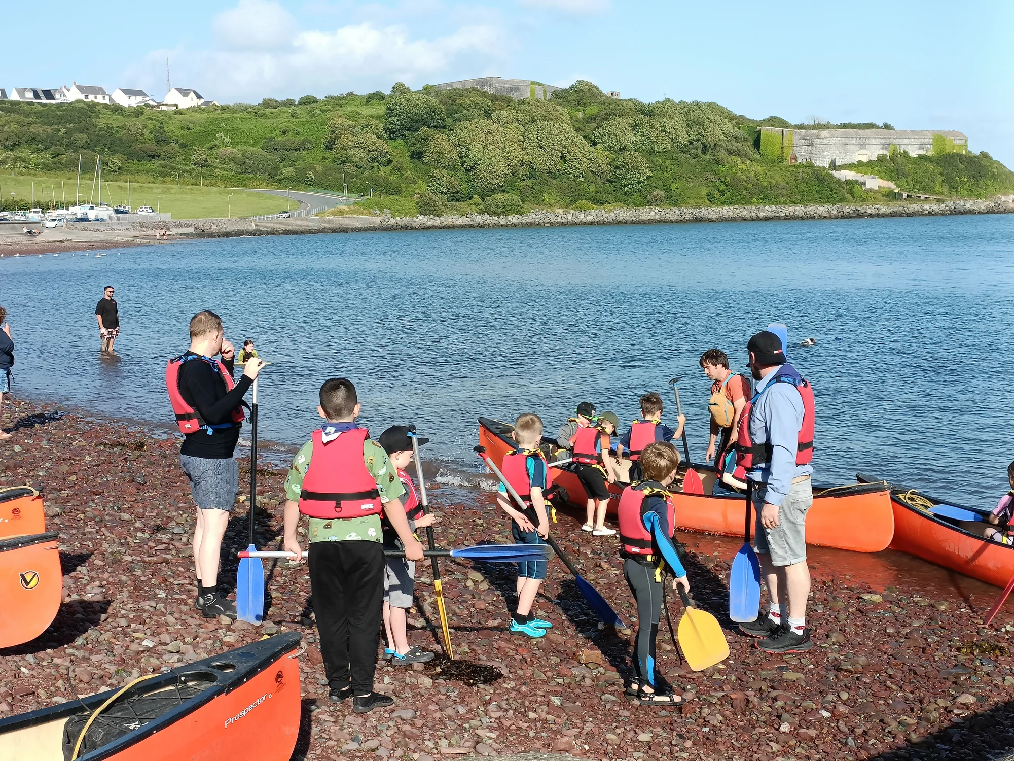 Sea Scouts preparing kayaks beside the water