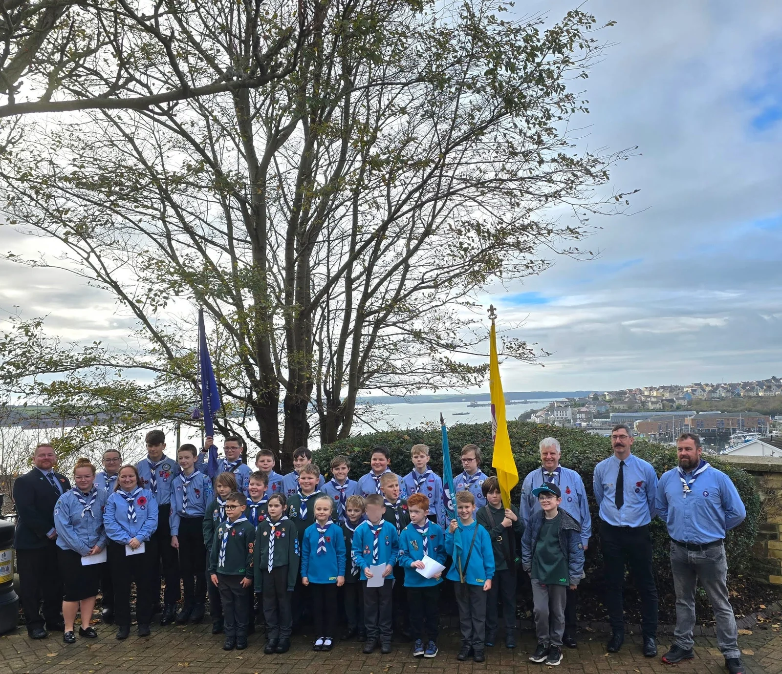 The group gathered outdoors with a flag